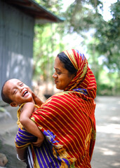 South asian mother with son,Bangladeshi hindu religious woman playing with her child keeping in arm and wearing traditional dress