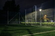 An amateur football field illuminated at night. A small football