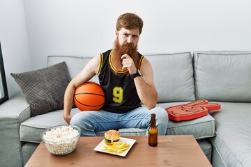 Canvas Print - Caucasian man with long beard holding basketball ball cheering tv game looking confident at the camera smiling with crossed arms and hand raised on chin. thinking positive.