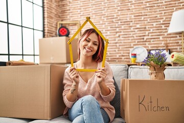 Sticker - Young caucasian woman sitting on the sofa at new home smiling and laughing hard out loud because funny crazy joke.