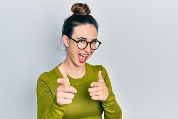 Poster - Young hispanic girl wearing casual clothes and glasses pointing fingers to camera with happy and funny face. good energy and vibes.