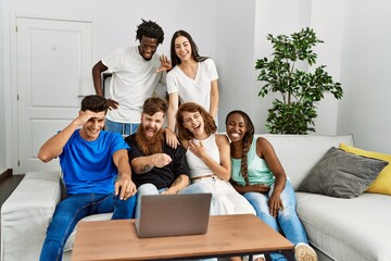 Wall Mural - Group of young friends smiling happy having video call using laptop at home.