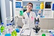 © Krakenimages.com - Young brunette woman working at scientist laboratory smiling happy pointing with hand and finger to the side