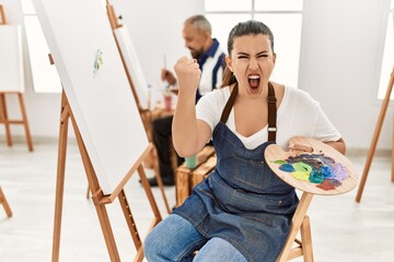 Canvas Print - Young artist woman at art studio annoyed and frustrated shouting with anger, yelling crazy with anger and hand raised