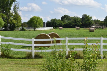 Sticker - Hay Bales by a White Fence in a Farm Field