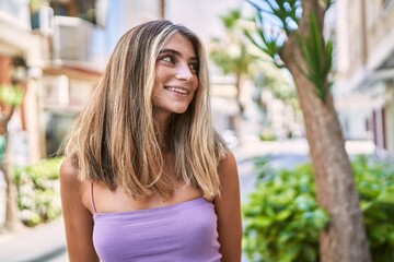 Poster - Young blonde girl smiling happy standing at the city.