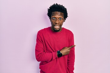 Sticker - Young african american man wearing casual clothes pointing aside worried and nervous with forefinger, concerned and surprised expression