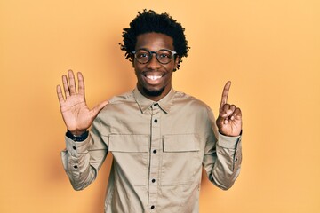 Poster - Young african american man wearing casual clothes and glasses showing and pointing up with fingers number six while smiling confident and happy.