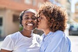 Fototapeta Miasto - African american women mother and daughter standing together kissing at street