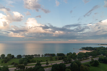 Wall Mural - beautiful aerial view of lake michigan at sunset with colorful cumulus clouds in the sky above and p