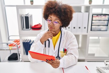 Poster - African american woman wearing doctor uniform having video call at clinic