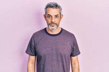 Poster - Handsome middle age man with grey hair wearing casual t shirt with serious expression on face. simple and natural looking at the camera.