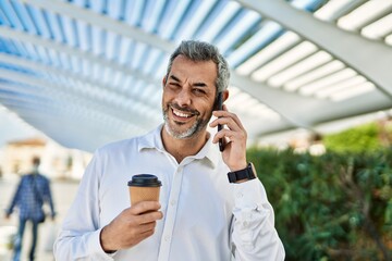 Sticker - Middle age grey-haired man talking on the smartphone drinking coffee at the city.