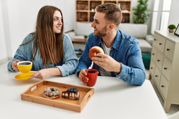 Sticker - Young caucasian couple having breakfast at home.