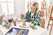 © Krakenimages.com - Young artist student girl smiling happy painting sitting on desk at art studio.