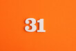 © Luis Echeverri Urrea - White wooden number 31 on eva rubber orange background