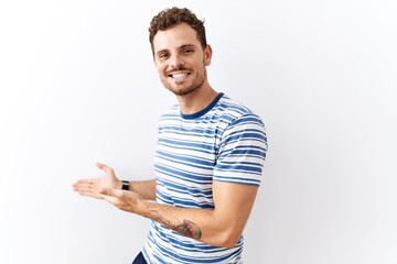 Poster - Handsome young man standing over isolated background inviting to enter smiling natural with open hand