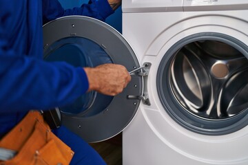 Sticker - Young hispanic man technician repairing washing machine at laundry room