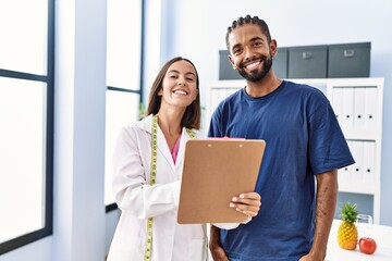 Poster - Man and woman wearing nutritionist uniform having nutrition session at clinic