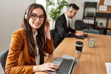 Two hispanic call center agents working at the office.