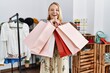 © Krakenimages.com - Young blonde woman holding shopping bags at clothing store
