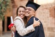 © Krakenimages.com - Man and woman mother and son hugging each other celebrating graduation at university