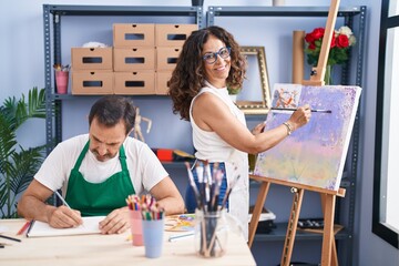 Wall Mural - Man and woman artists smiling confident drawing at art studio