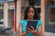 © Krakenimages.com - African american woman using touchpad with serious expression at street