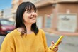 © Krakenimages.com - Young brunette woman smiling happy using smartphone at the city