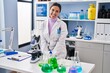 © Krakenimages.com - Young brunette woman working at scientist laboratory looking positive and happy standing and smiling with a confident smile showing teeth