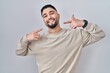 © Krakenimages.com - Young handsome man standing over isolated background smiling cheerful showing and pointing with fingers teeth and mouth. dental health concept.
