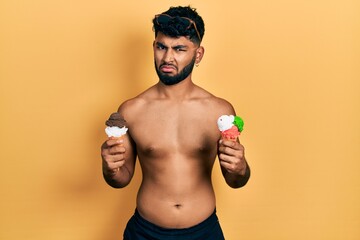 Sticker - Arab man with beard wearing swimwear eating two ice cream cones clueless and confused expression. doubt concept.