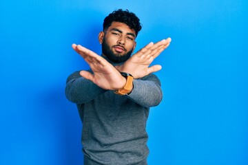 Poster - Arab man with beard wearing turtleneck sweater rejection expression crossing arms and palms doing negative sign, angry face