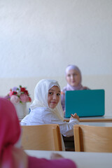 Wall Mural - Happy Muslim student girl during the class in the school classroom.	