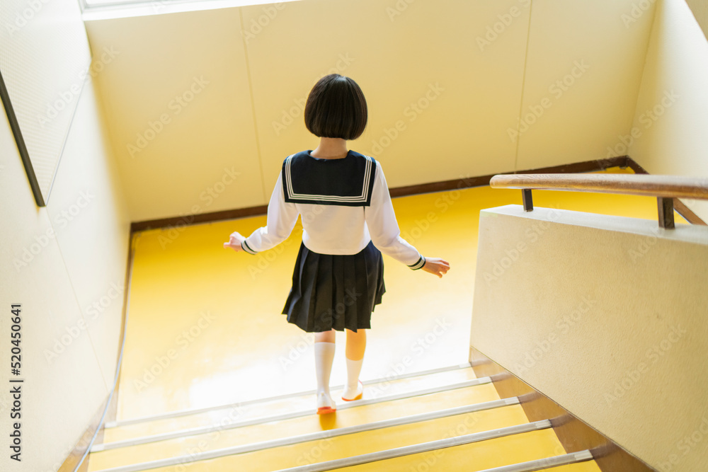 Foto de Stock 学校 階段をかけ降りる女子高生 | Adobe Stock