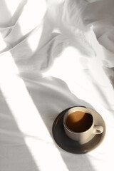 Wall Mural - Cup of aromatic coffee on bed in morning, above view. Space for text