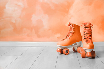 Wall Mural - vintage roller skates on floor near orange wall. space for text