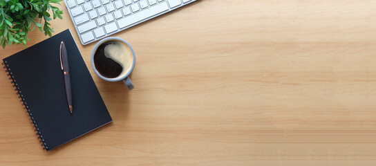 Wall Mural - Simple workplace with wireless keyboard, notebook and coffee cup on wooden table. Top view with copy space for your text.