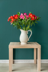 Poster - Vase with bouquet of beautiful alstroemeria flowers on table near color wall