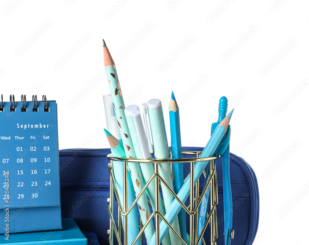 Cup with school stationery, pencil case and calendar on white background
