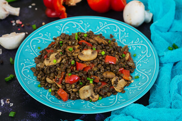 Wall Mural - Delicious lentils with pepper and mushrooms on dark background