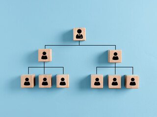 company hierarchical organizational chart of wooden cubes on blue background. human resources manage