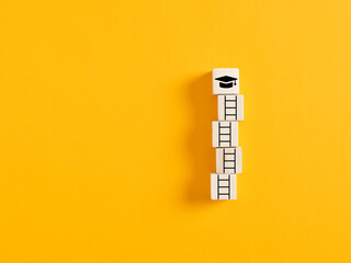 ladder of success with wooden cubes and academic graduation cap. achieving education, graduation and