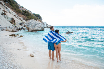 couple with greece flag at sea beach