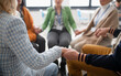 © Halfpoint - Group of senior people sitting in circle during therapy session, holding hands and praying together.