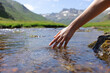 © Antonioguillem - Woman wand touching river water in the mountain