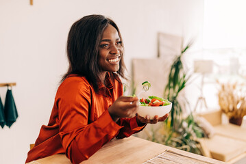 beautiful young woman eating salad in the kitchen in the morning. healthy food. close up. portrait s
