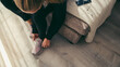 © Timm Creative - High angle view of woman tying shoelace on floor at home
