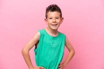 Wall Mural - Little caucasian boy isolated on pink background posing with arms at hip and smiling