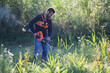 © Melinda Nagy - man trimming weed with weed trimmer in summer
